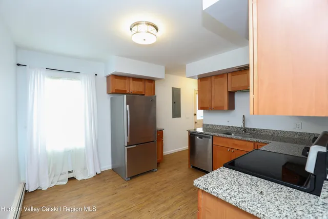 a kitchen with granite countertop a refrigerator and a sink