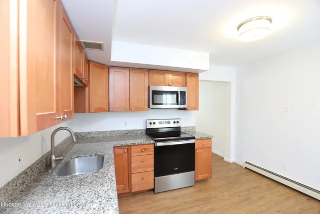 a kitchen with stainless steel appliances granite countertop a stove a sink and a microwave