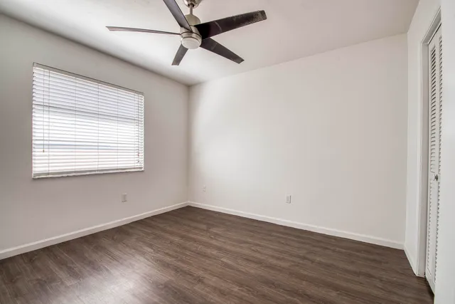 a view of a big room with wooden floor and windows
