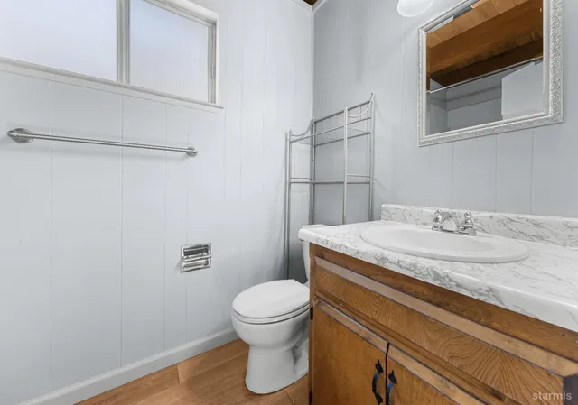 a bathroom with a granite countertop sink toilet and mirror