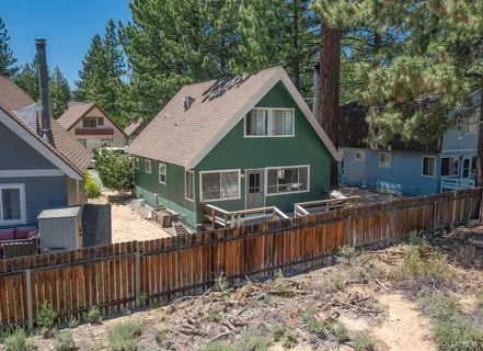 an aerial view of a house with outdoor space and a lake view in back
