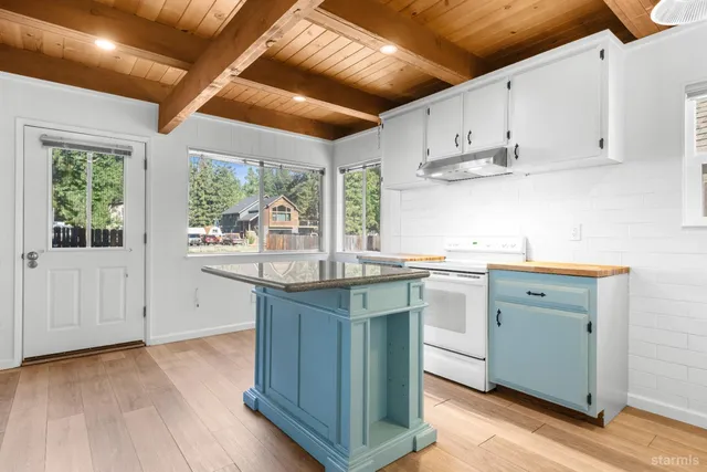 a kitchen with wooden cabinets a sink a window and appliances