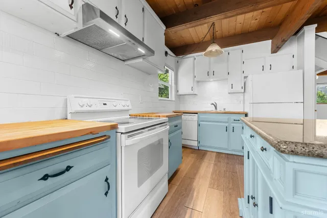 a kitchen with a sink a stove and cabinets
