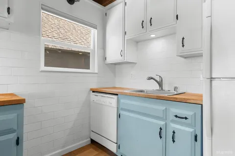 a kitchen with stainless steel appliances white cabinets and a window