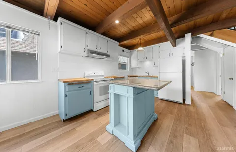 a kitchen with stainless steel appliances a white stove top oven a sink and dishwasher