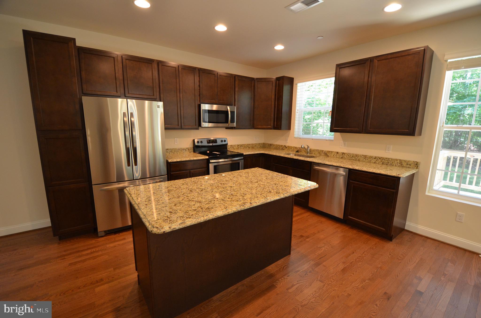 5917 Sneed Drive Deale, MD 20751 - Photo 8 of 26 a kitchen with stainless steel appliances granite countertop a refrigerator a sink a stove a microwave and wooden floor