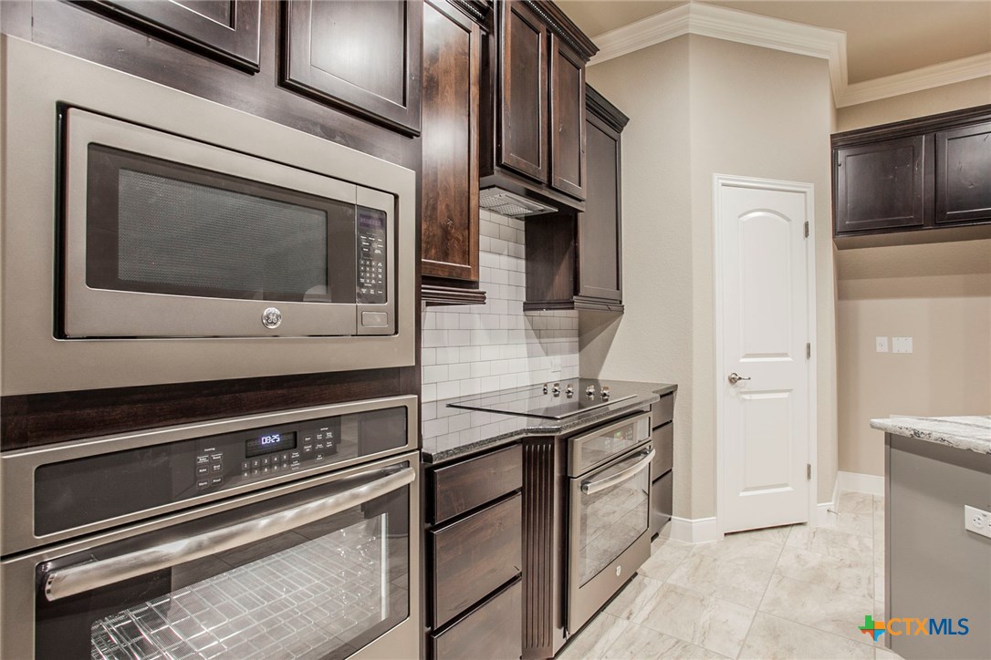 549 Wills Point Way Belton, TX 76513 - Photo 3 of 31 a kitchen with stainless steel appliances granite countertop a stove microwave and sink
