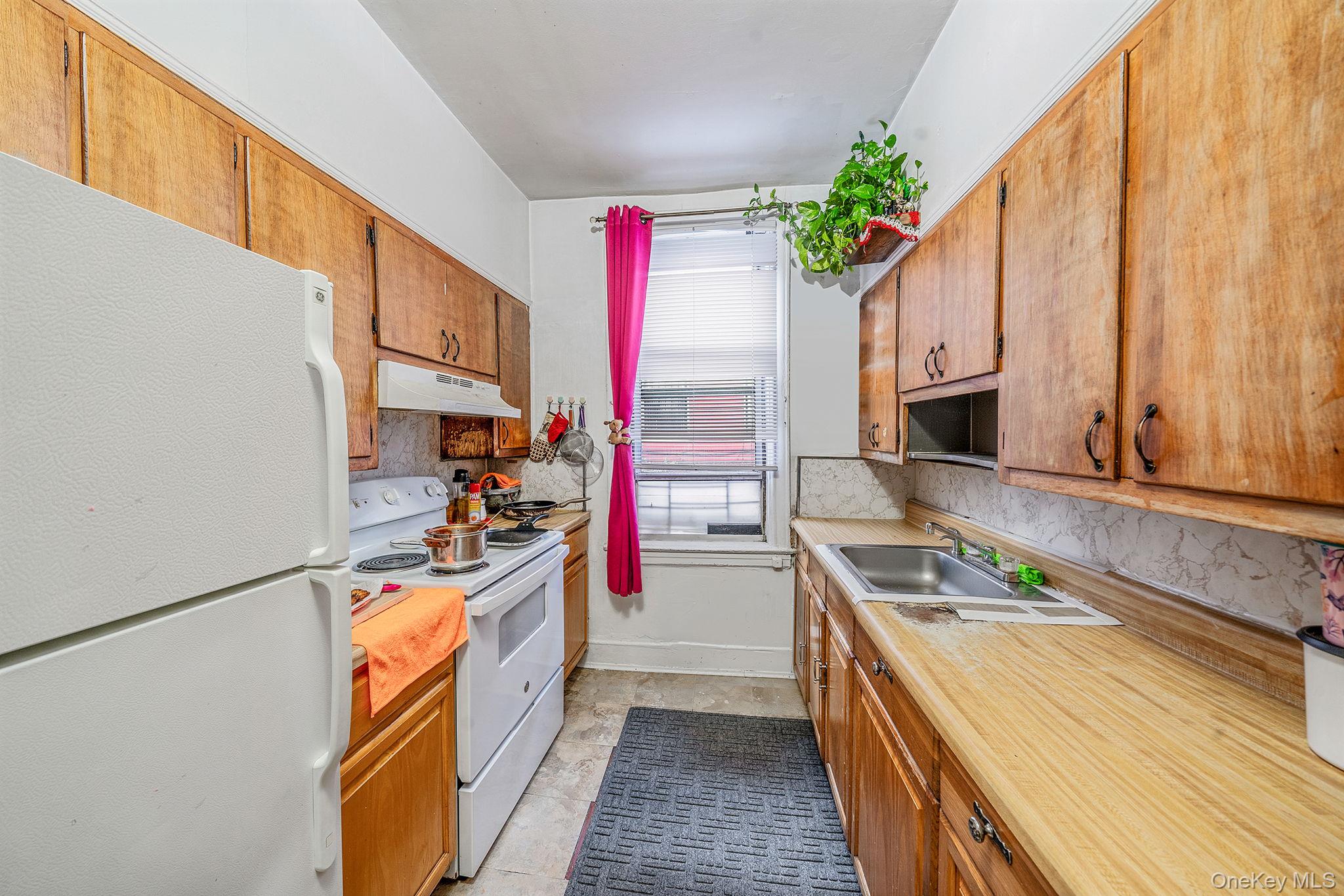 108-76 38th Avenue Queens, NY 11368 - Photo 13 of 38 a kitchen with stainless steel appliances granite countertop a stove a sink and a refrigerator