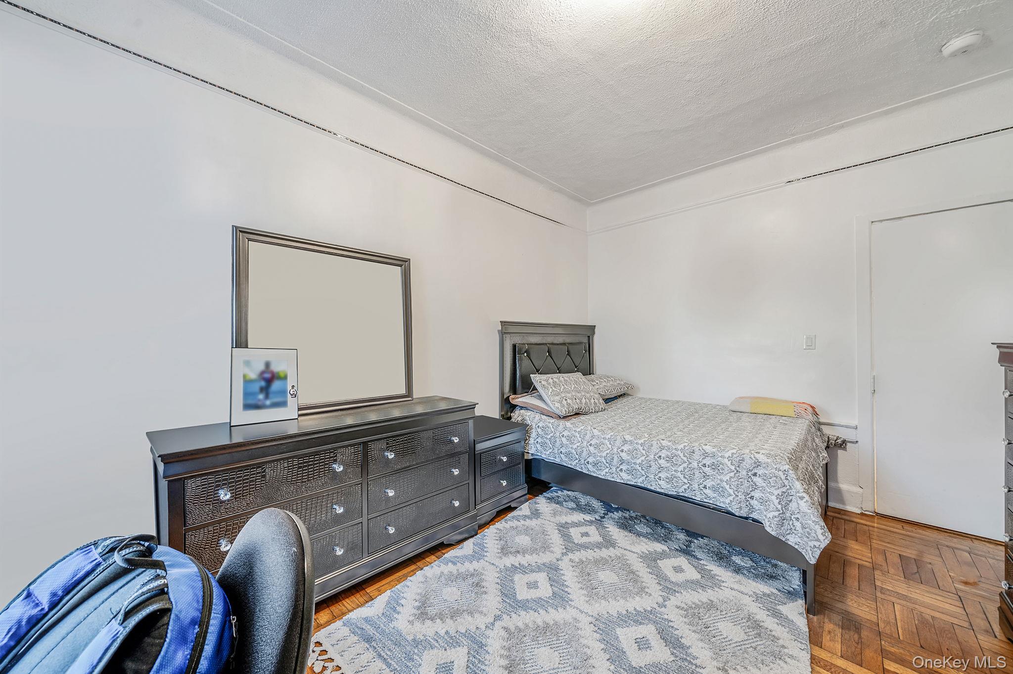 108-76 38th Avenue Queens, NY 11368 - Photo 22 of 38 a bedroom with a bed and dresser