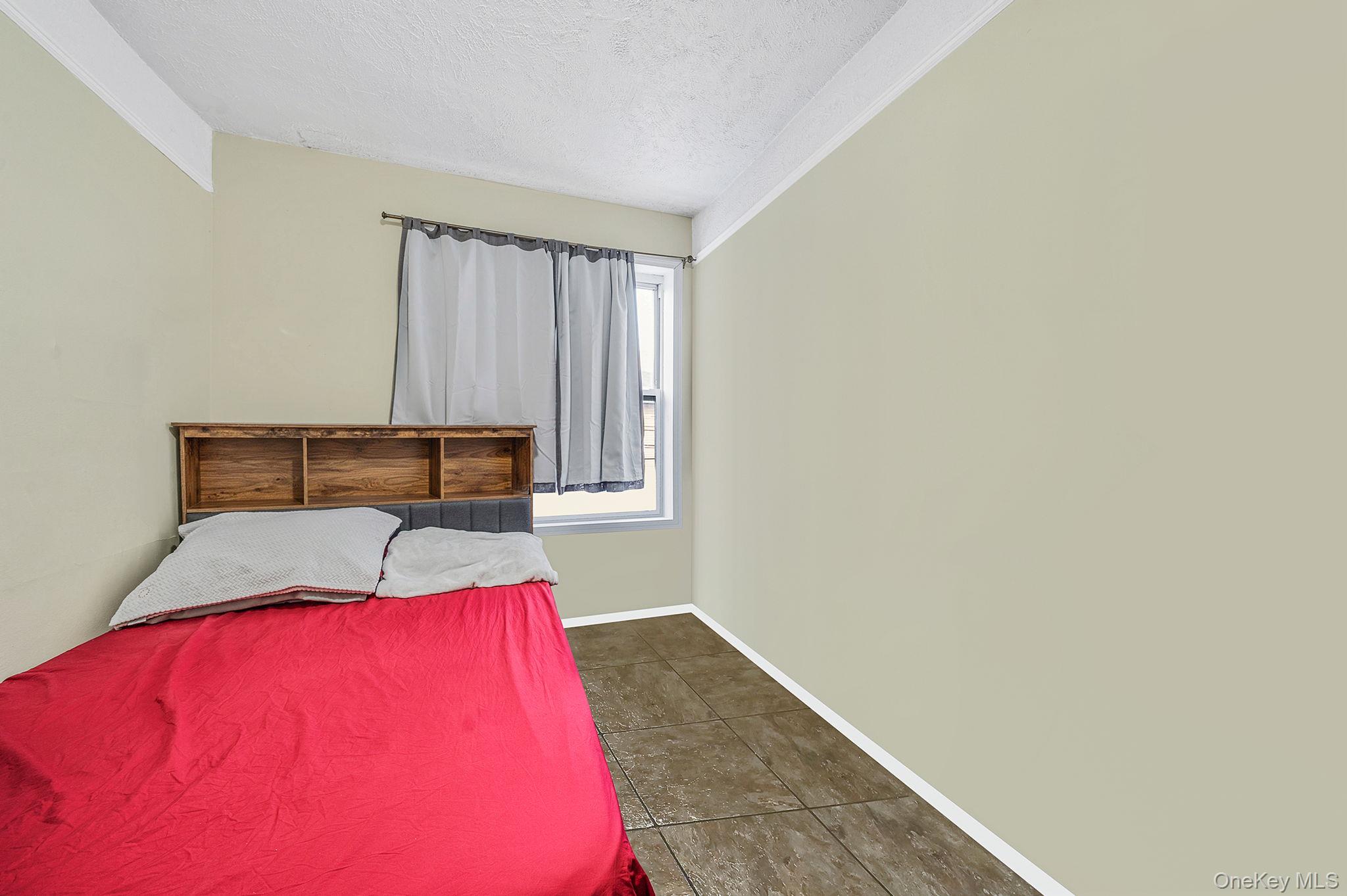 108-76 38th Avenue Queens, NY 11368 - Photo 23 of 38 a bedroom with a bed and a potted plant