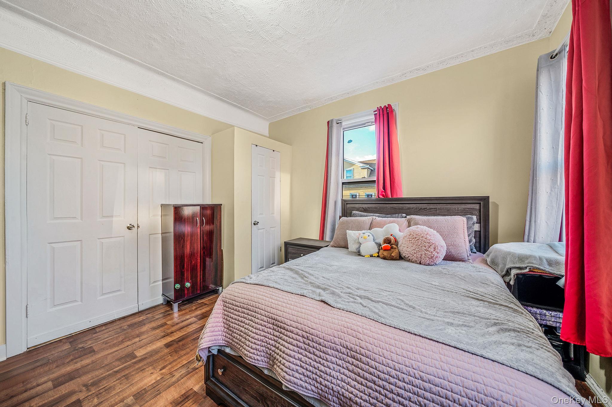 108-76 38th Avenue Queens, NY 11368 - Photo 29 of 38 a bedroom with a bed and a closet