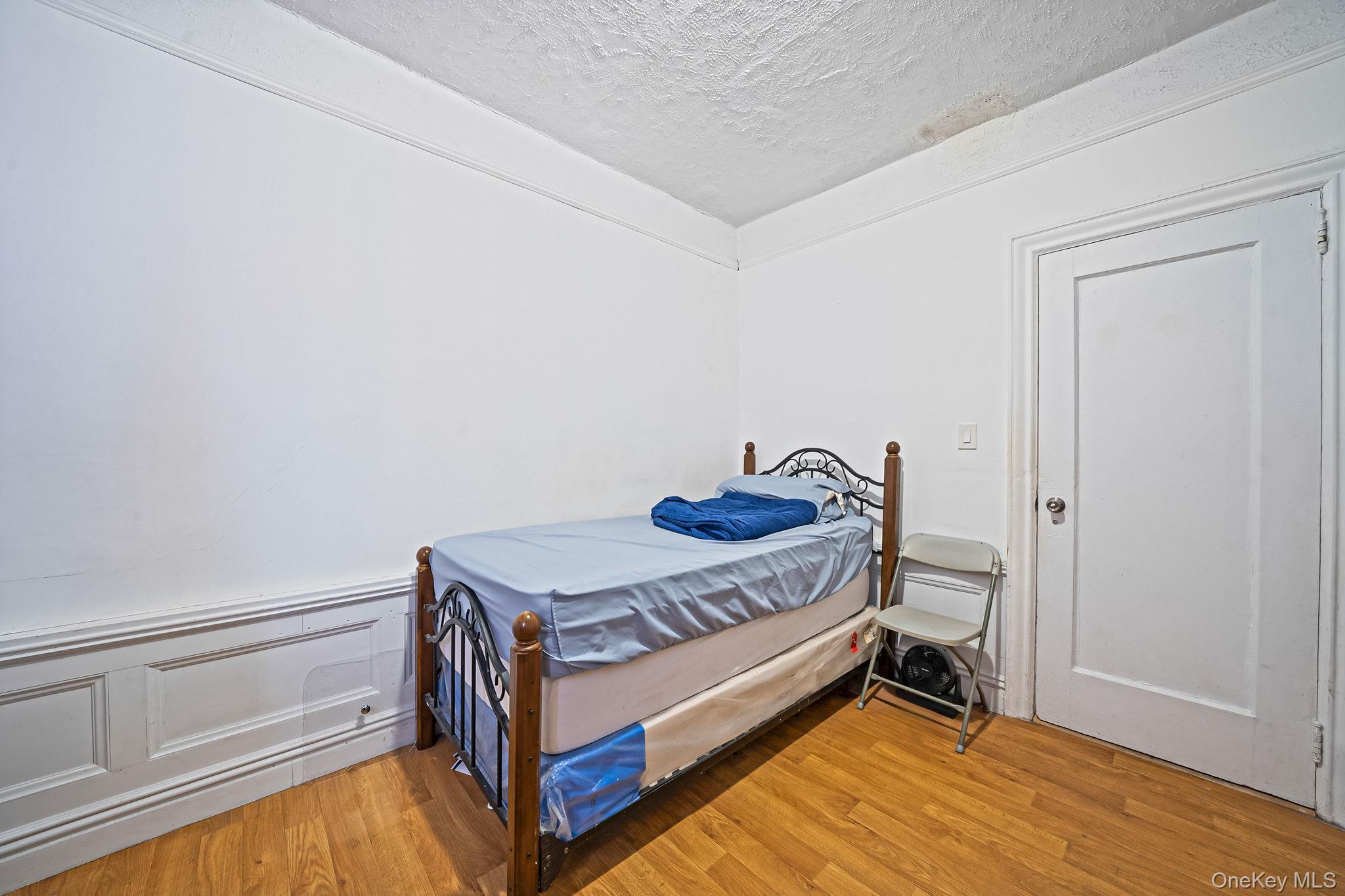 108-76 38th Avenue Queens, NY 11368 - Photo 30 of 38 a room with a bed and a table