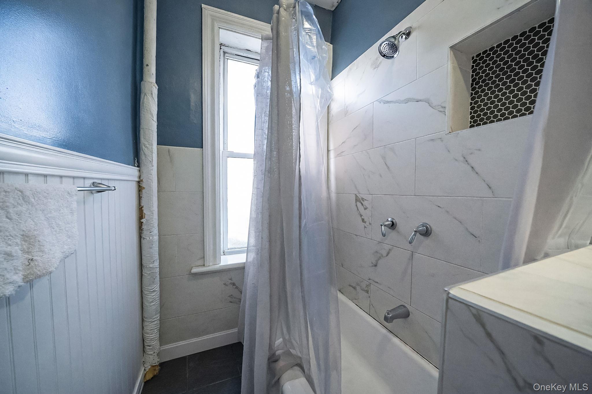 108-76 38th Avenue Queens, NY 11368 - Photo 34 of 38 a bathroom with a bathtub and shower