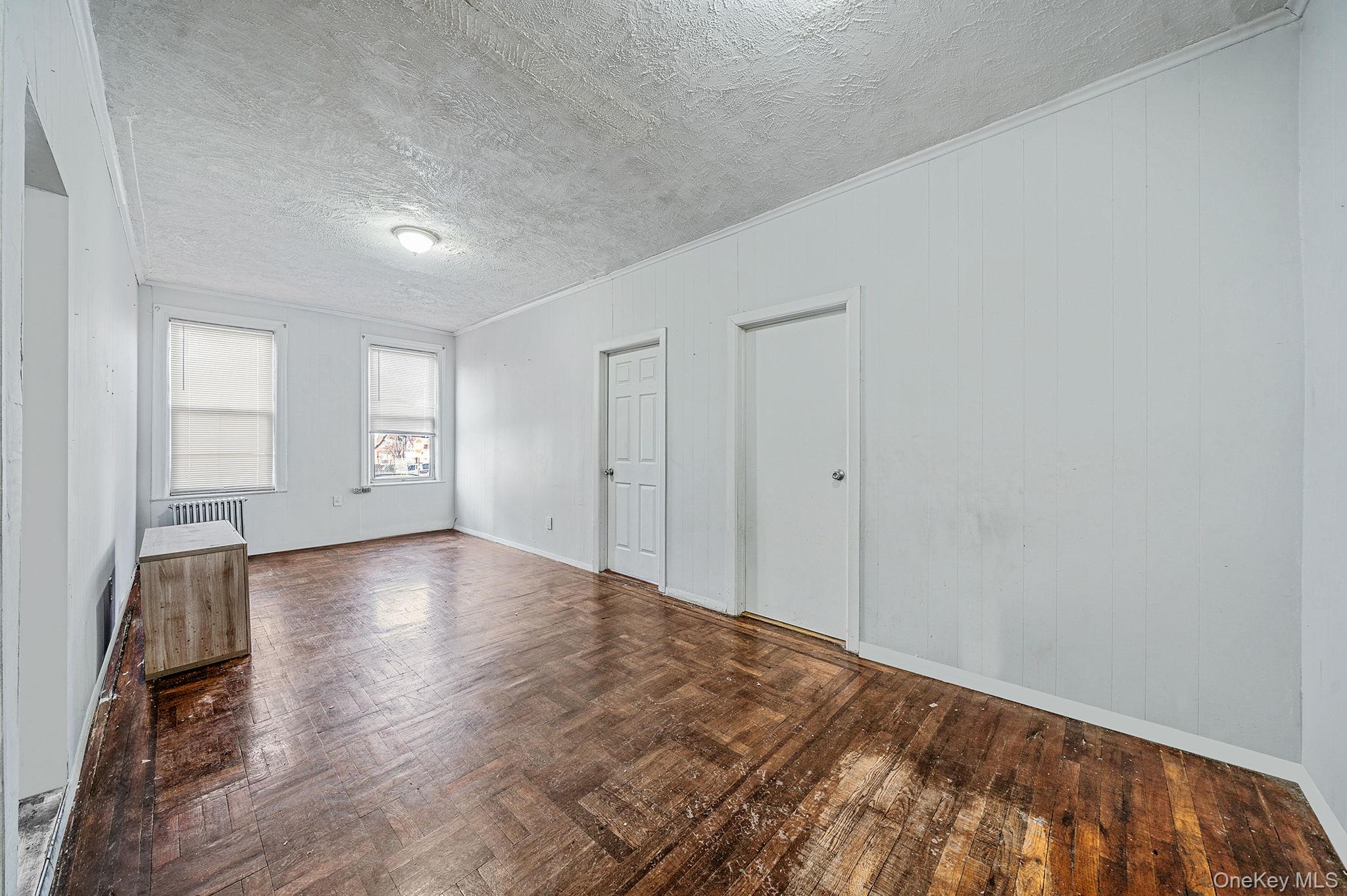 108-76 38th Avenue Queens, NY 11368 - Photo 5 of 38 a view of empty room with wooden floor and fan