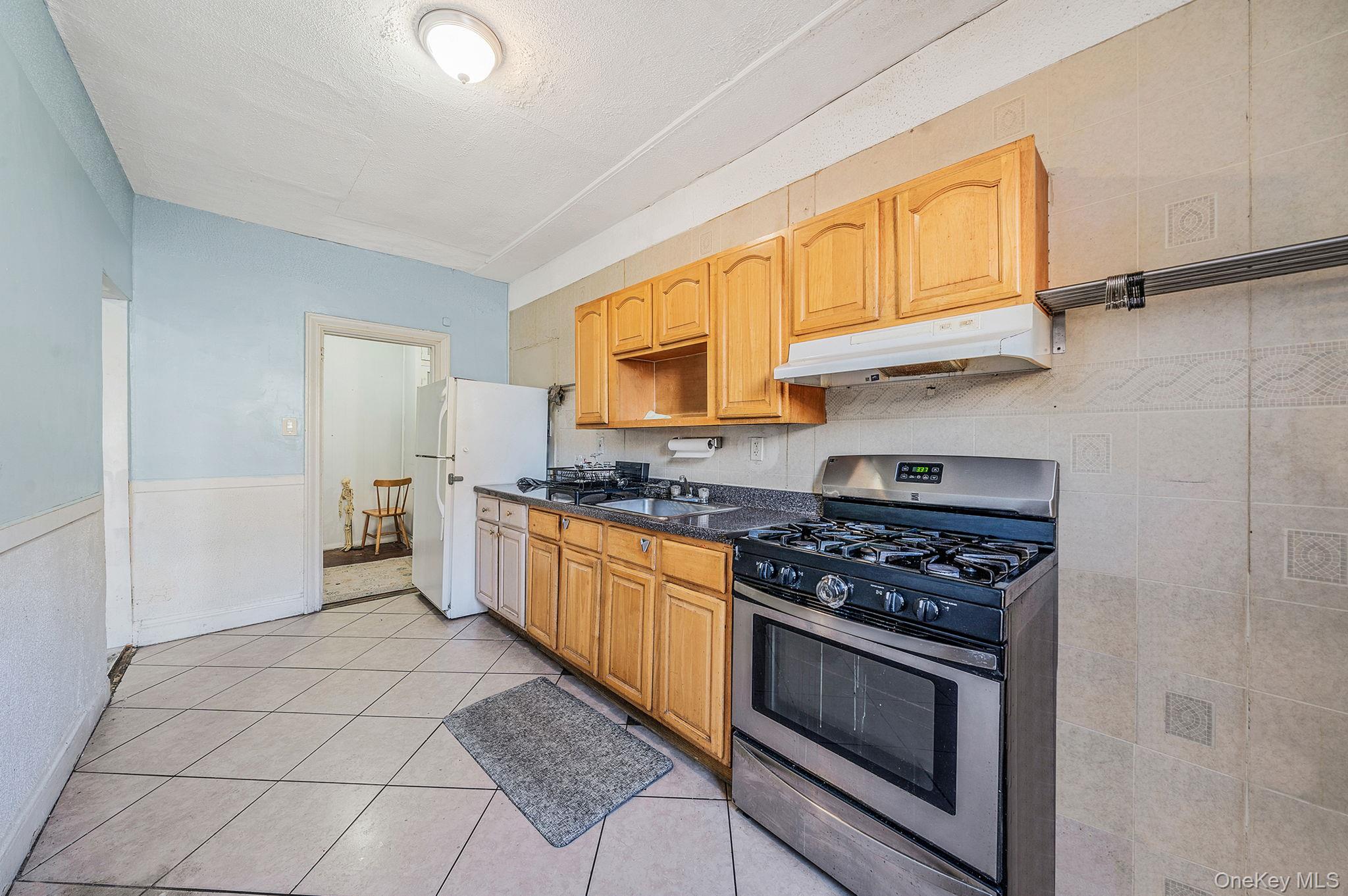 108-76 38th Avenue Queens, NY 11368 - Photo 7 of 38 a kitchen with stainless steel appliances a stove a sink and a microwave