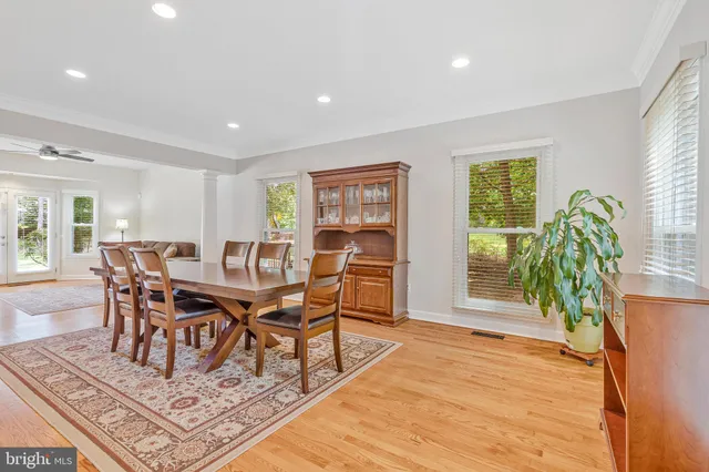 a kitchen with stainless steel appliances kitchen island granite countertop wooden floors and a view of living room