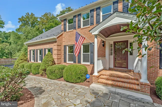 a view of a brick house with many windows and plants