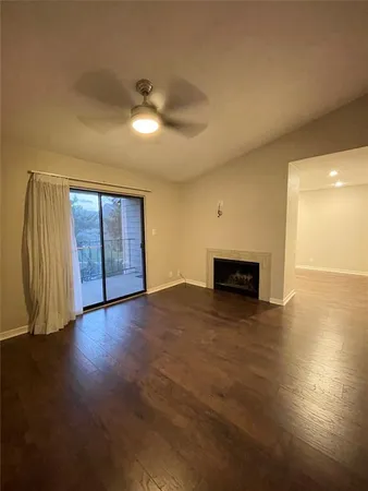 an empty room with wooden floor and fireplace