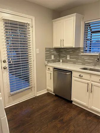 a view of a kitchen with a sink a microwave and cabinets