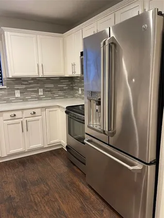 a kitchen with granite countertop a refrigerator and a sink