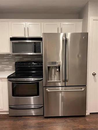 a metallic refrigerator freezer sitting in a kitchen