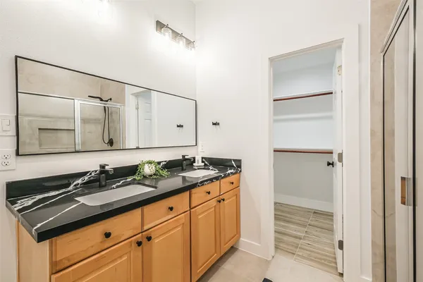 a bathroom with a granite countertop sink and a mirror