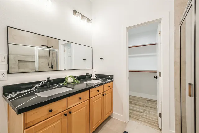 a bathroom with a granite countertop sink and a mirror
