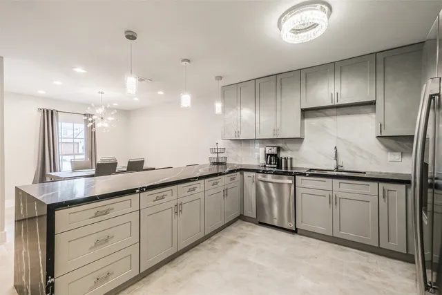 a kitchen with kitchen island a sink stove and refrigerator