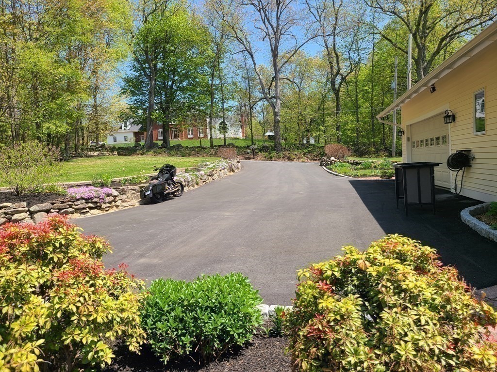 103 Burbank Road Sutton, MA 01590 - Photo 6 of 36 a view of a street with potted plants and large trees