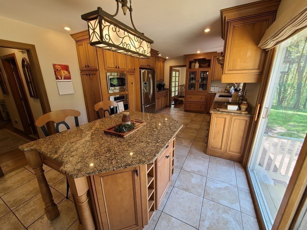 103 Burbank Road Sutton, MA 01590 - Photo 9 of 36 a kitchen with stainless steel appliances granite countertop sink stove refrigerator and microwave