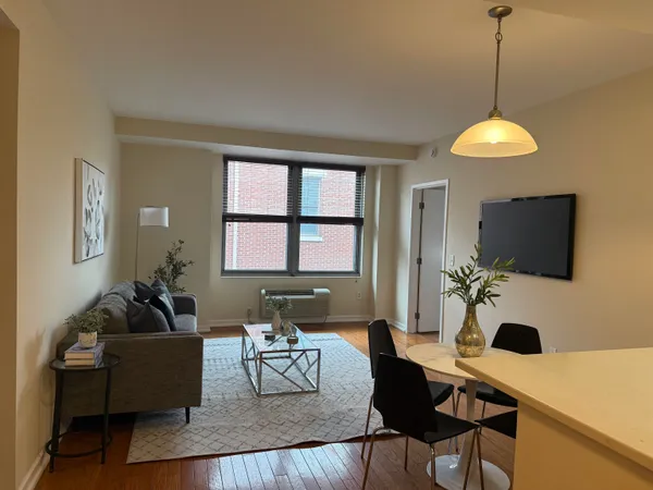 a living room with furniture a chandelier and a flat screen tv