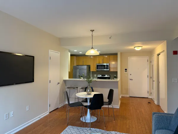 a living room with furniture a flat screen tv and kitchen view