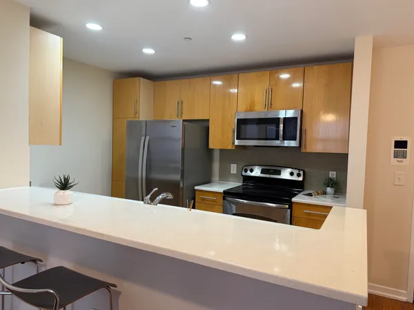 a kitchen with stainless steel appliances a refrigerator sink and microwave