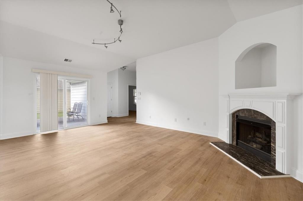 156 Cottage Club Drive Locust Grove, GA 30248 - Photo 12 of 34 a view of empty room with fireplace and wooden floor