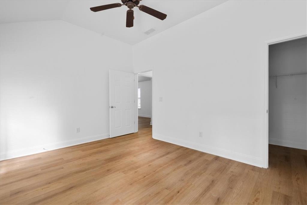156 Cottage Club Drive Locust Grove, GA 30248 - Photo 19 of 34 an empty room with wooden floor fan and windows