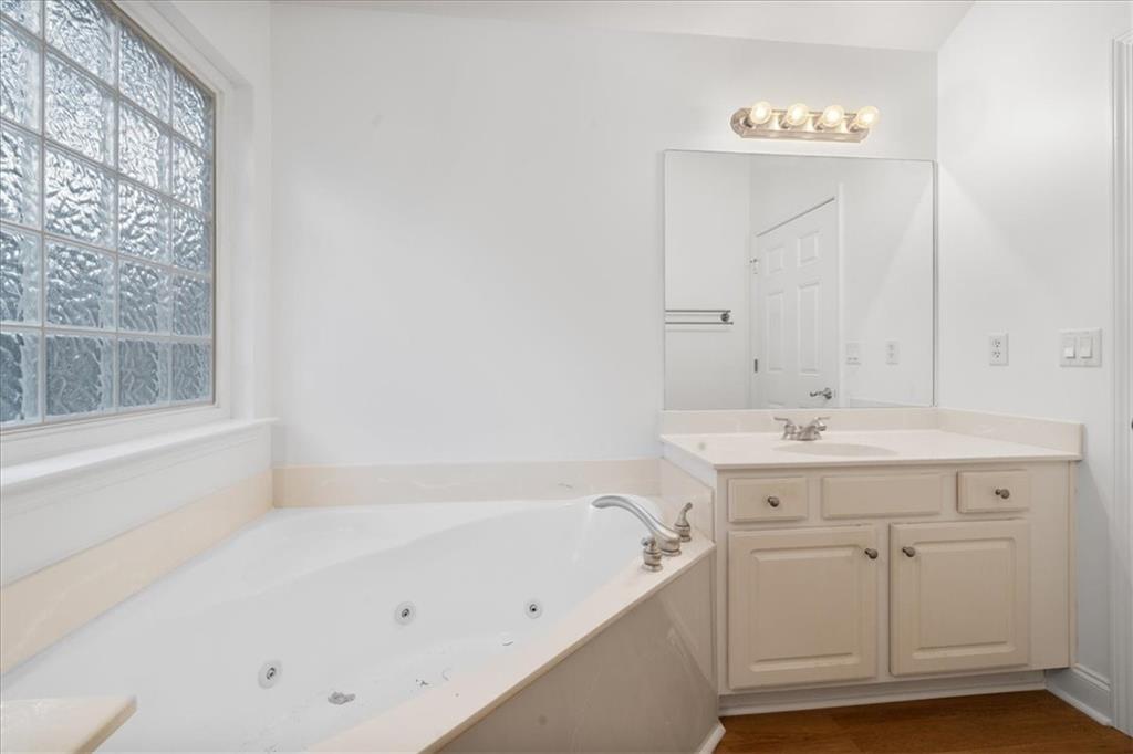 156 Cottage Club Drive Locust Grove, GA 30248 - Photo 24 of 34 a bathroom with a bathtub and a sink
