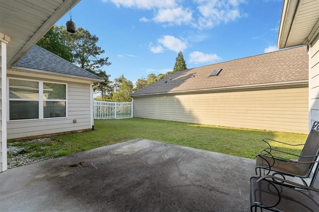 156 Cottage Club Drive Locust Grove, GA 30248 - Photo 28 of 34 a view of a backyard with couches under an umbrella