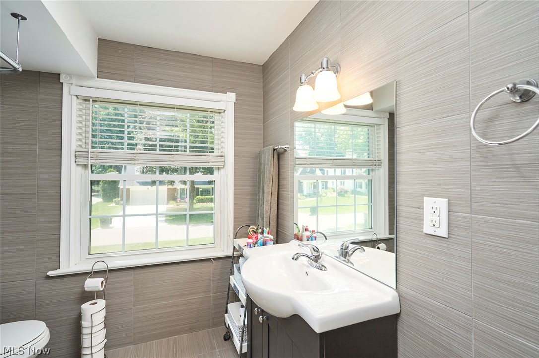183 Overwood Road Akron, OH 44313 - Photo 23 of 34 Bathroom featuring grey horizontal-patterned wall tiling and a white framed window with blinds