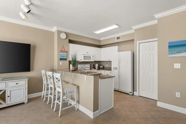 a kitchen with stainless steel appliances kitchen island granite countertop a table and chairs in it
