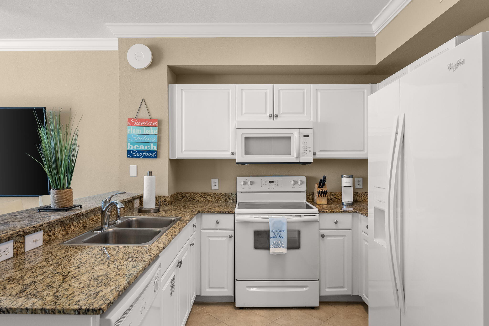 16819 Front Beach Road, Unit 411 Panama City Beach, FL 32413 - Photo 15 of 44 a kitchen with stainless steel appliances granite countertop a sink stove and refrigerator