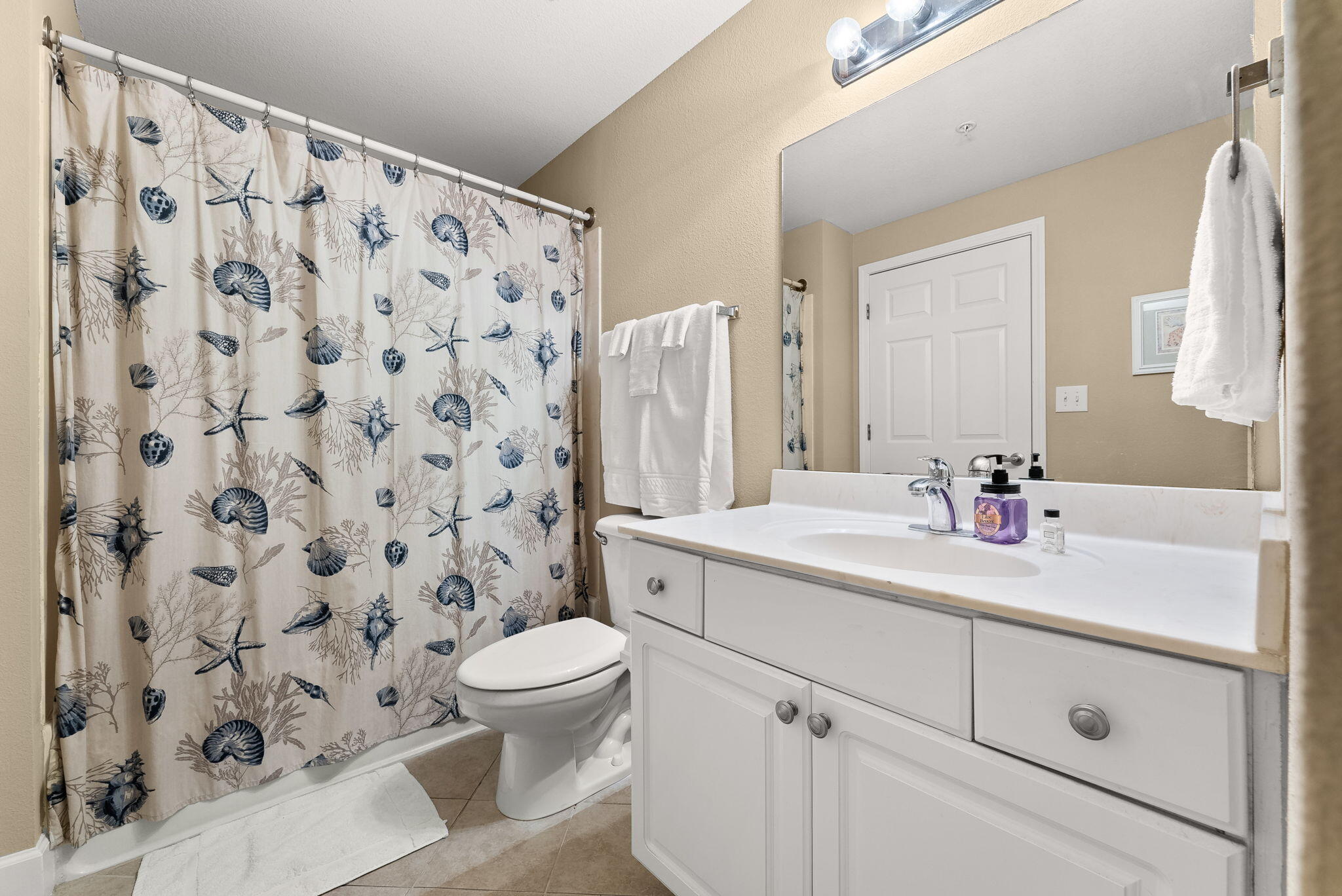 16819 Front Beach Road, Unit 411 Panama City Beach, FL 32413 - Photo 27 of 44 a bathroom with a sink a toilet and a mirror