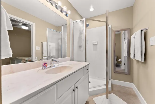 a bathroom with a shower sink vanity and mirror