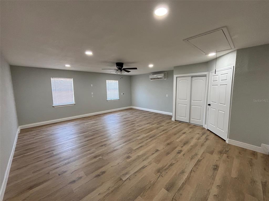 9801 Southeast Sunset Harbor Road Summerfield, FL 34491 - Photo 20 of 37 a view of empty room with wooden floor and fan