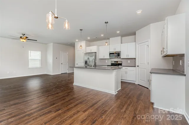 a kitchen with kitchen island a white counter top space cabinets and stainless steel appliances