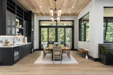 a living room with furniture large window and wooden floor