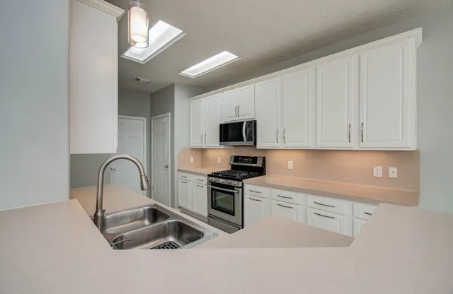 a view of a house with backyard and wooden fence
