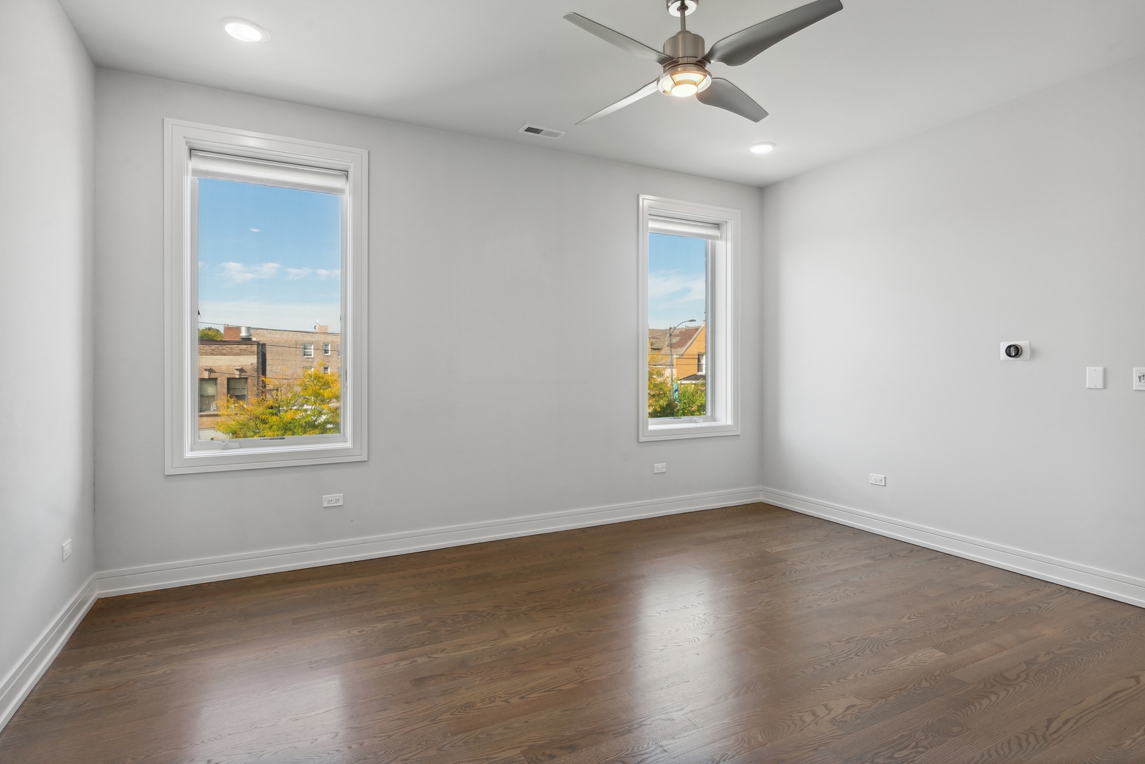 2352 West Winona Street, Unit 2W Chicago, IL 60625 - Photo 11 of 22 an empty room with windows and fan