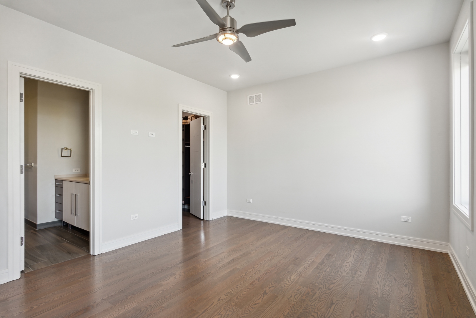 2352 West Winona Street, Unit 2W Chicago, IL 60625 - Photo 12 of 22 an empty room with wooden floor and ceiling fan