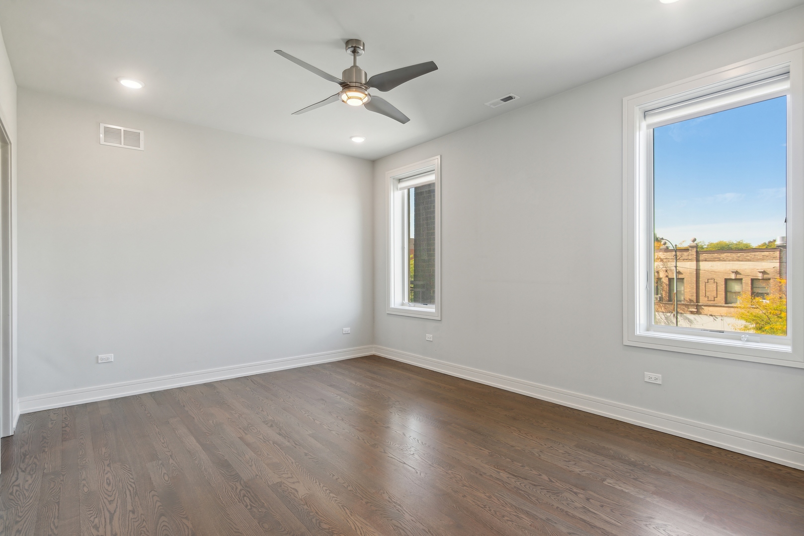 2352 West Winona Street, Unit 2W Chicago, IL 60625 - Photo 10 of 22 an empty room with wooden floor and windows