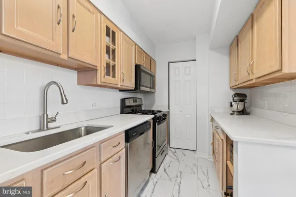a kitchen with stainless steel appliances granite countertop a sink and a stove
